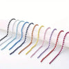A collection of ball bead chains in various pastel colors, including blue, purple, and yellow, laid out for DIY jewelry.