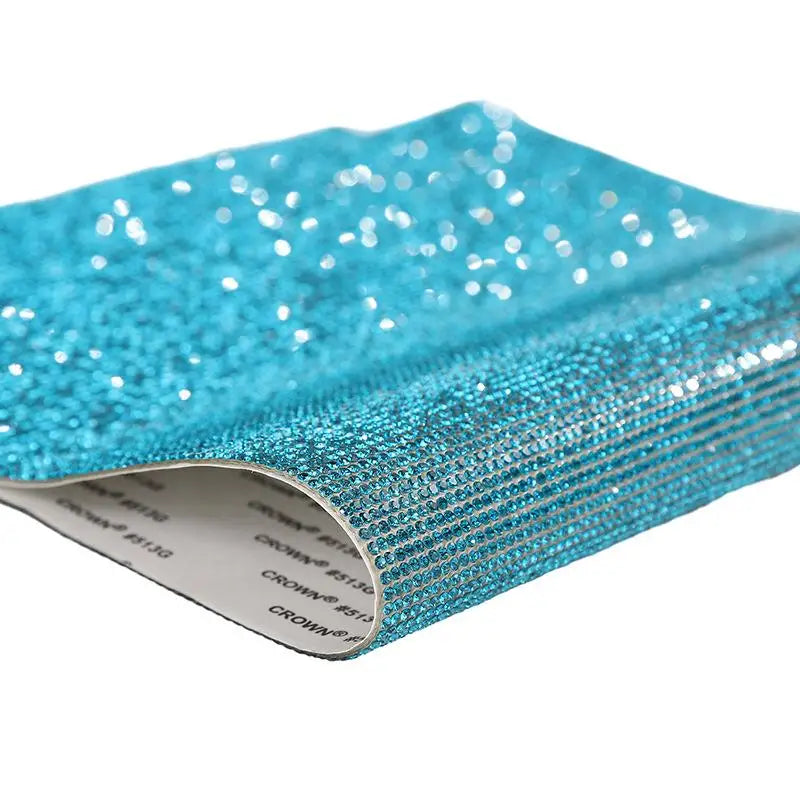 A close-up of sparkling turquoise rhinestone adhesive tape for DIY crafts and decor.