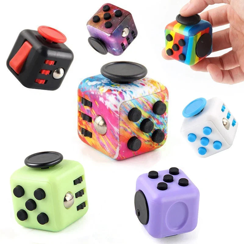 A collection of colorful fidget cubes in various colors and designs, including black, purple, green, and yellow.