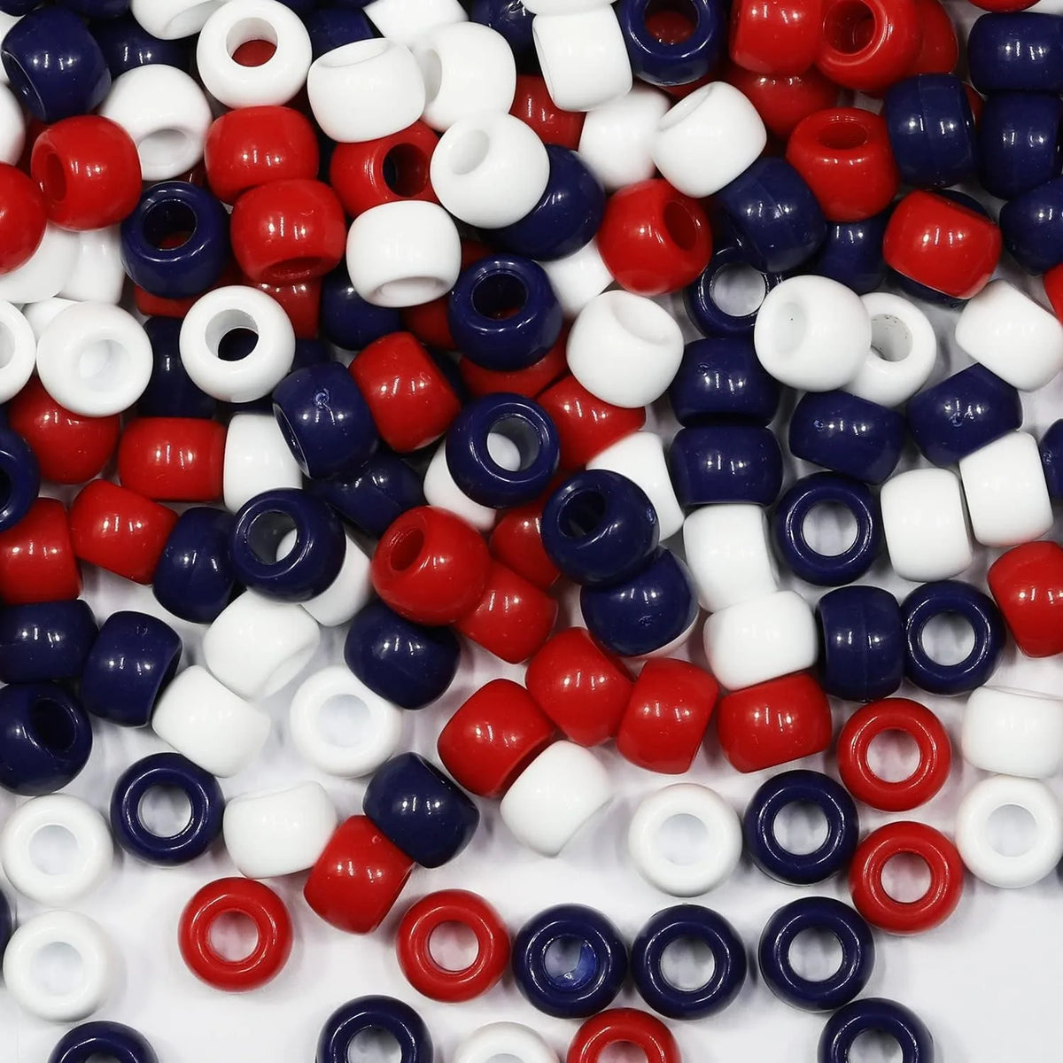 A pile of multicolor pony beads in various colors including red, blue, white, and purple.