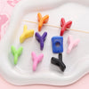 A collection of colorful acrylic letter beads in various shapes and colors arranged on a white plate.
