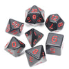 A collection of black acrylic dice showing various numbers and shapes used for tabletop role-playing games
