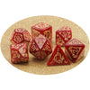 A set of red polyhedral dice, including d20s and dodecahedrons, scattered on a gold glitter background.
