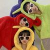 Three models wearing fuzzy hooded costumes in red, purple, and lime green colors