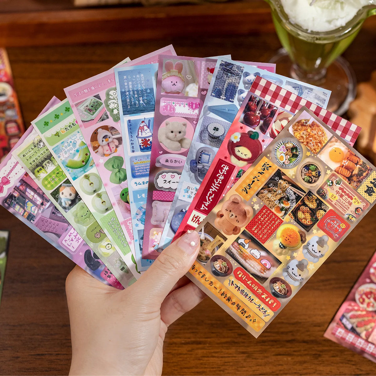 A hand holds a stack of Sweet Dream Duet sticker books featuring retro vintage kawaii aesthetic stickers for crafting.