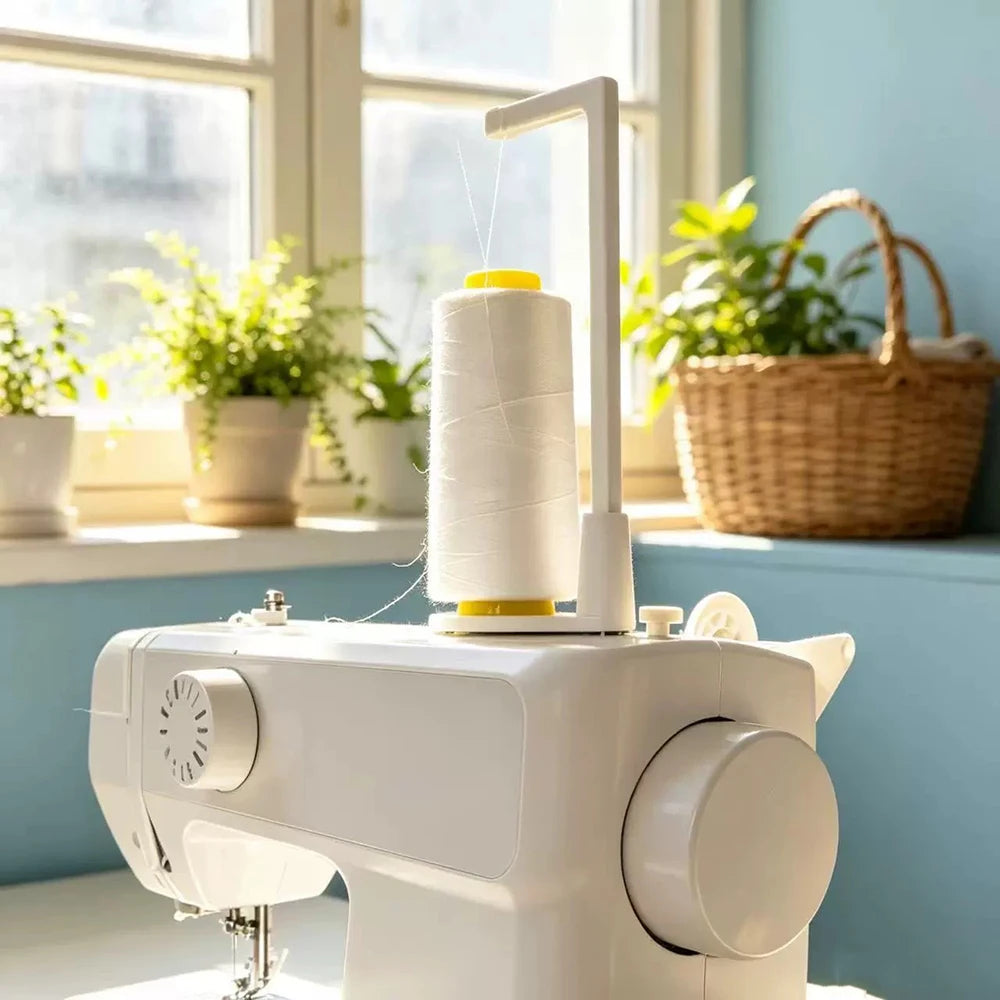 A white vertical sewing machine spool holder with a thread guide is displayed on a light blue windowsill.