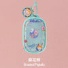 A light blue pendant keychain featuring a cute monster character and various hair accessories.