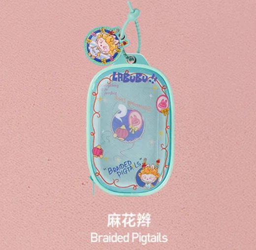 A light blue pendant keychain featuring a cute monster character and various hair accessories.
