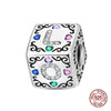 A silver rubik's cube charm featuring a letter L with colorful gemstone accents.