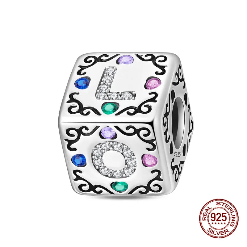 A silver rubik's cube charm featuring a letter L with colorful gemstone accents.