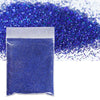 A small plastic bag filled with vibrant blue holographic glitter powder scattered across a white background.