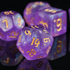 A close-up of a set of translucent purple glitter polyhedral dice resting on a reflective surface.
