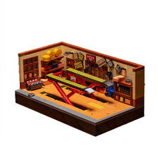 A wooden building block set depicting a retro car repair shop with various tools and equipment.