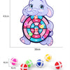 A purple elephant shaped dart board with colored sticky balls and a set of various colored dart balls.