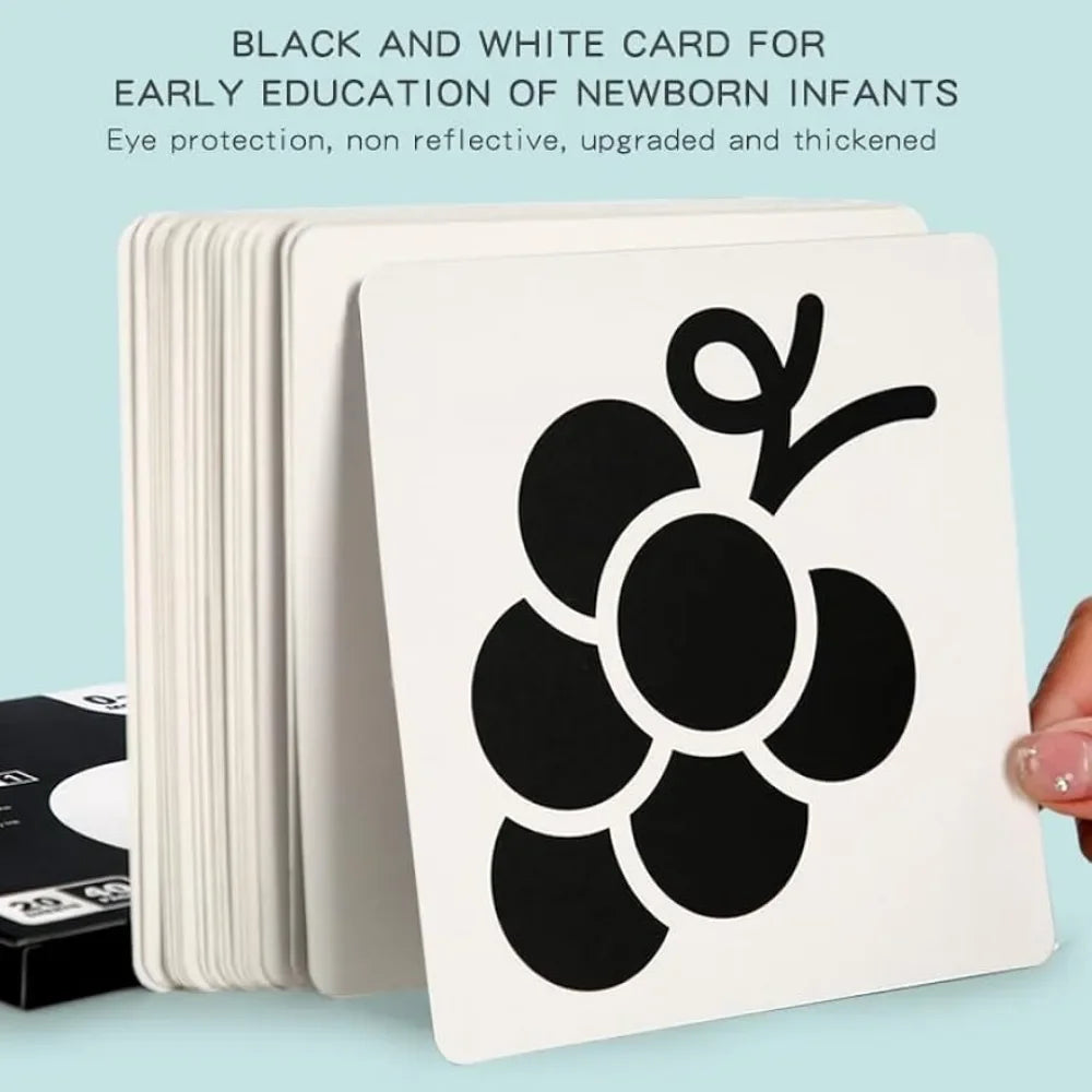 A stack of black and white cards for newborn infants featuring a large black grape design.