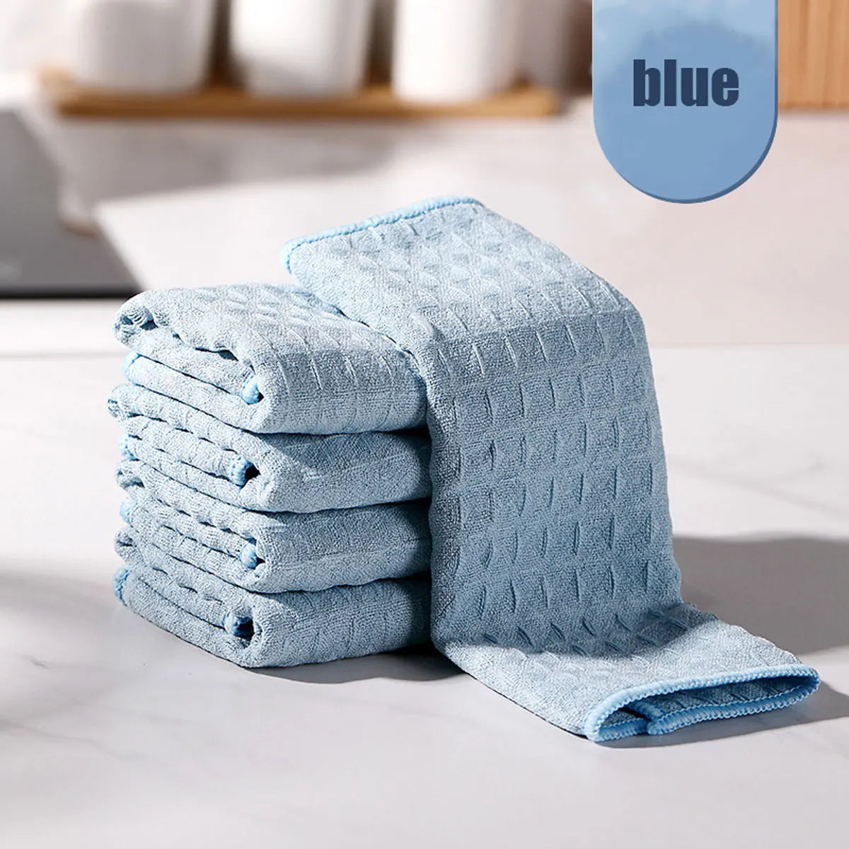 A stack of light blue ultra-absorbent microfiber kitchen cleaning cloths on a white surface.