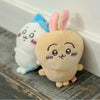 A soft, light yellow Chiikawa Usagi plush keychain charm with pink ears and a blue backpack accessory.