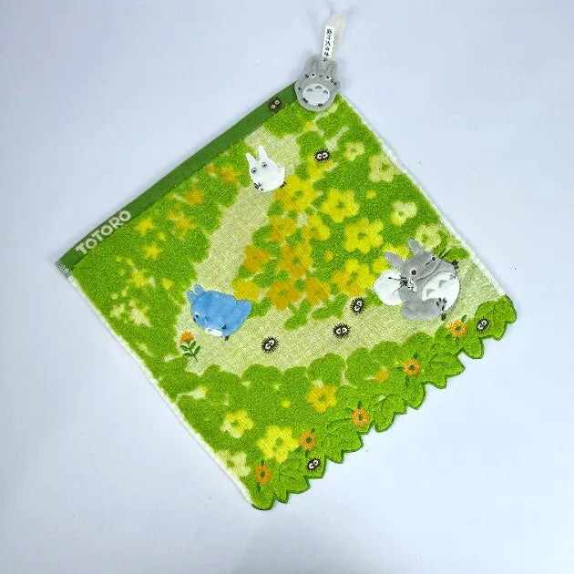 A green felt mat featuring a yellow floral pattern and small white animal plush toys.