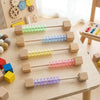 Wooden sensory activity board for toddlers featuring colorful plastic beads on wooden sticks