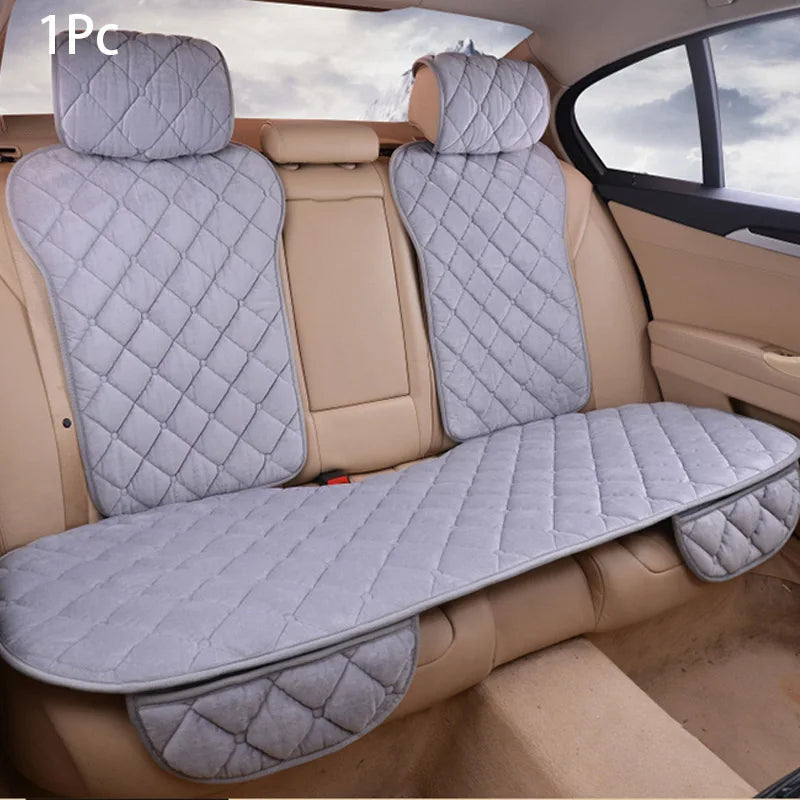 A gray quilted car seat protector with a matching seat cover is shown inside a vehicle.