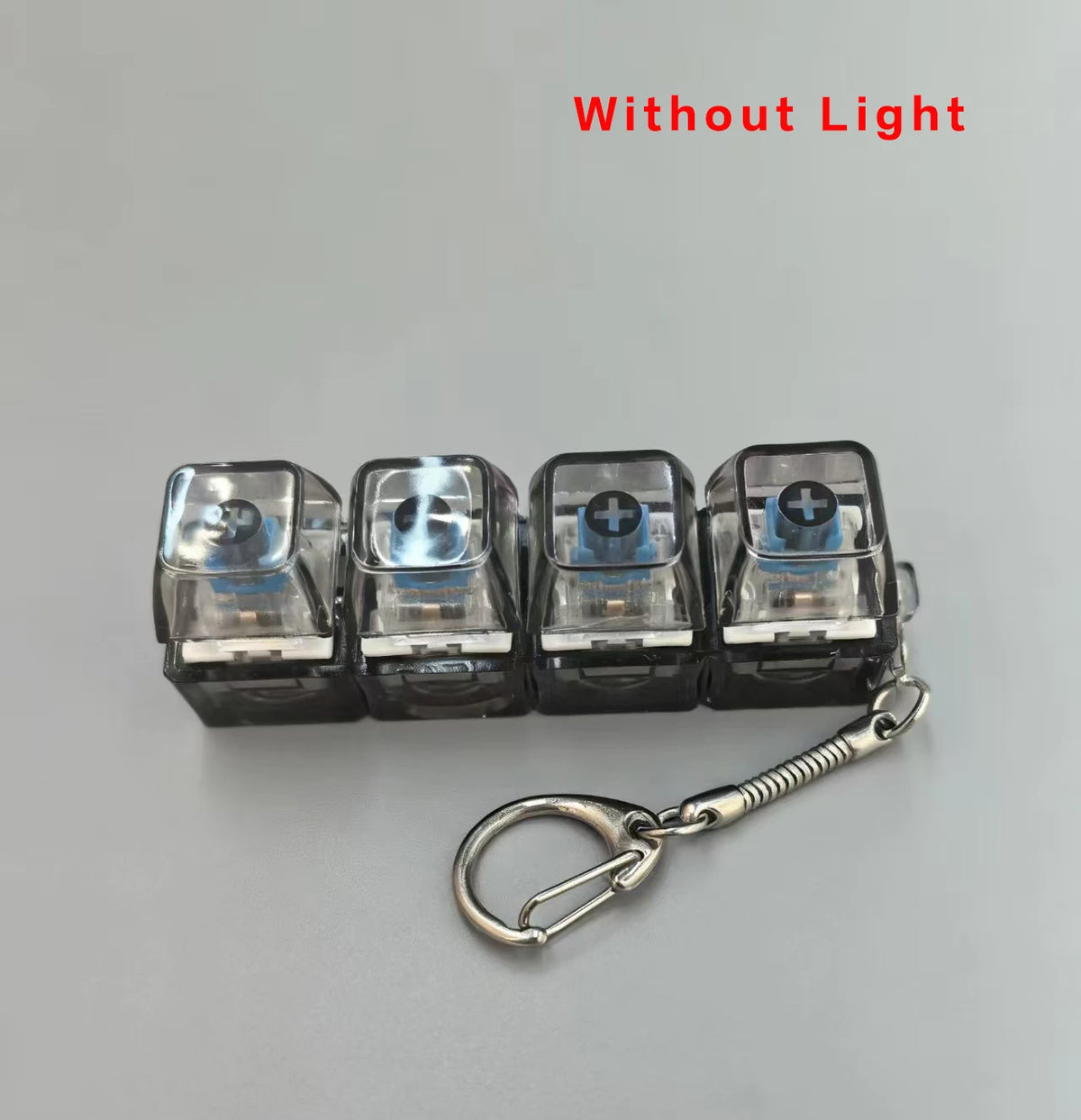 A set of four clear acrylic key buttons with a plus sign on them attached to a silver keychain.