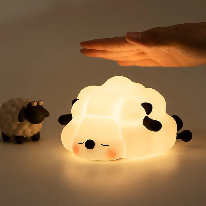 A cute silicone rabbit night light glowing softly on a surface, with a hand hovering above it.