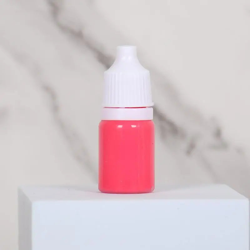 A small pink bottle of water marbling paint art kit for kids sitting on a white surface.