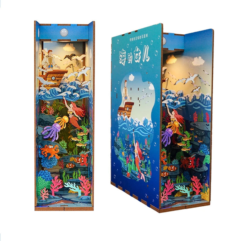 A wooden DIY book nook kit featuring a detailed miniature landscape with aquatic and aerial scenes illuminated by LED lightin