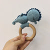 A handmade wooden baby rattle and teether ring featuring a blue textured silicone or fabric head attached to a natural wood r