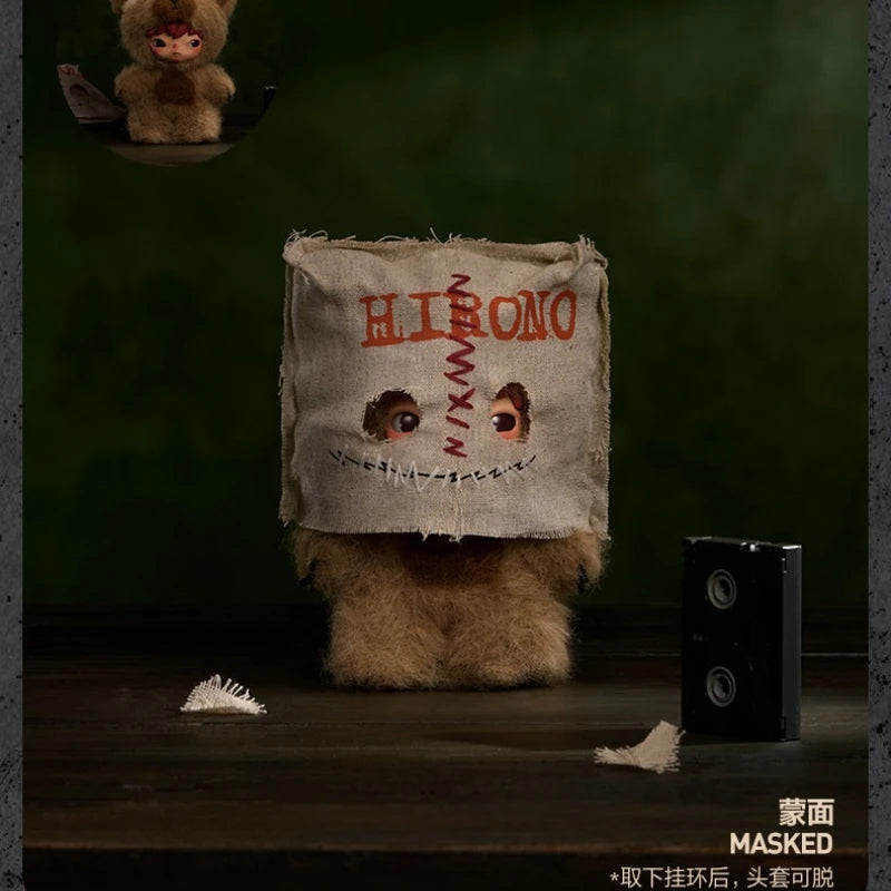 A plush doll resembling a masked face is displayed on a wooden surface with a small speaker nearby.