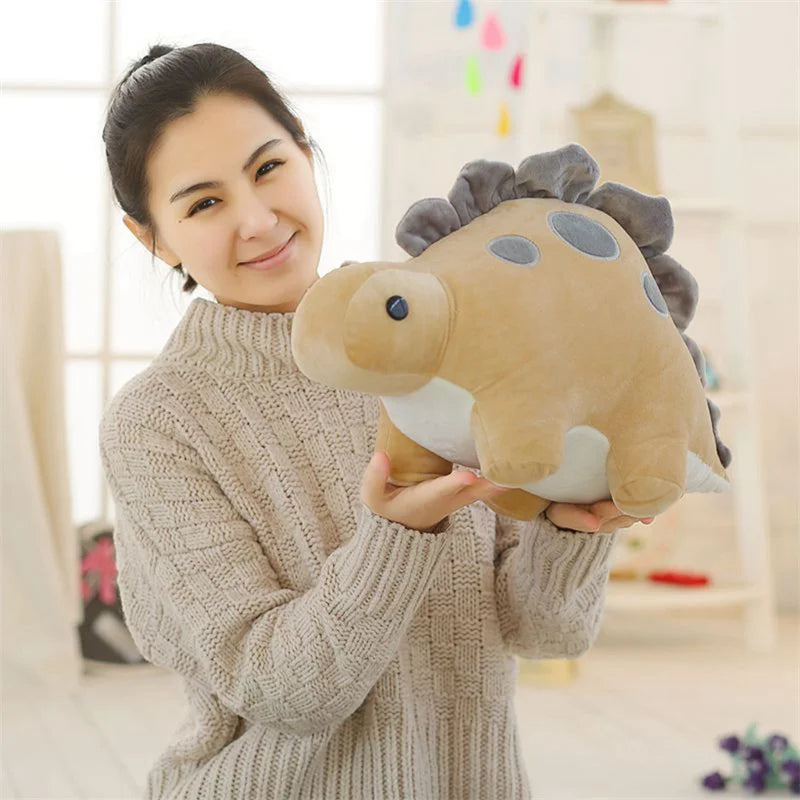 A woman is holding an adorable soft triceratops plush dinosaur toy.
