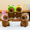 Three adorable plush toys shaped like capybaras in green, yellow, and brown.