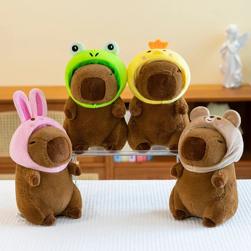 Three adorable plush toys shaped like capybaras in green, yellow, and brown.