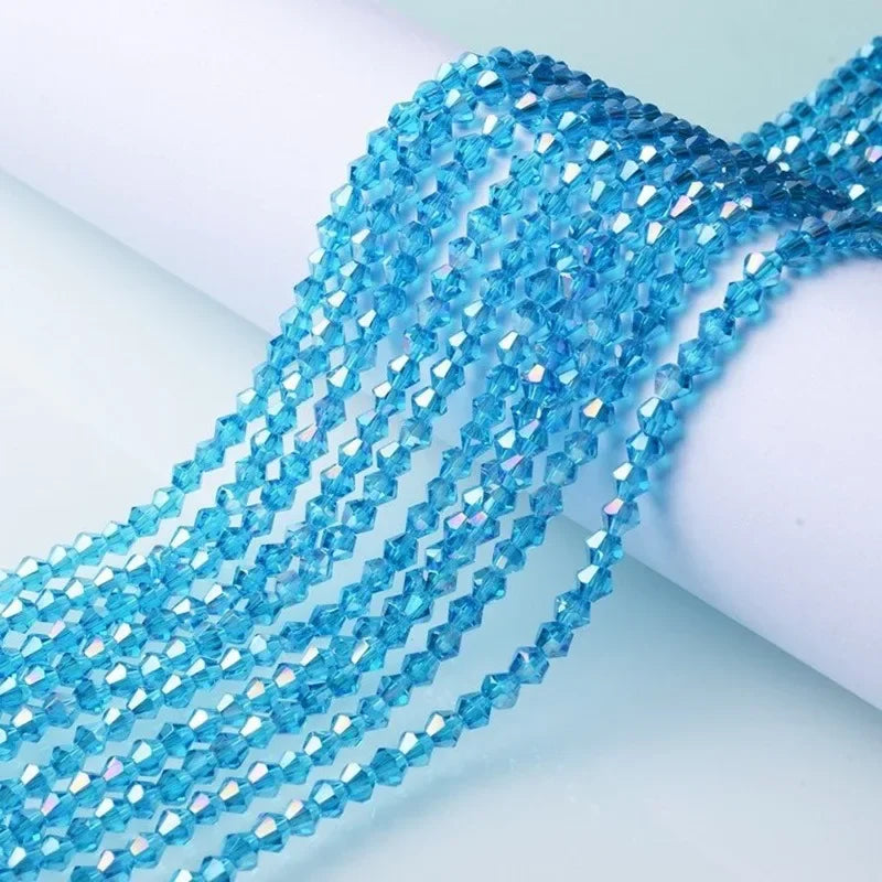 A close-up of blue crystal beads strung together, showcasing facets and a shimmering texture for jewelry making.