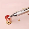 A silver gradient rotating dotting pen is shown applying a colored substance to a nail or craft item.