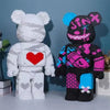 A white and black building block model of a bear and a pink and black striped monster bear are displayed side by side.