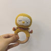 A handmade wooden baby rattle and teether ring shaped like an otter, featuring yellow and white yarn details.