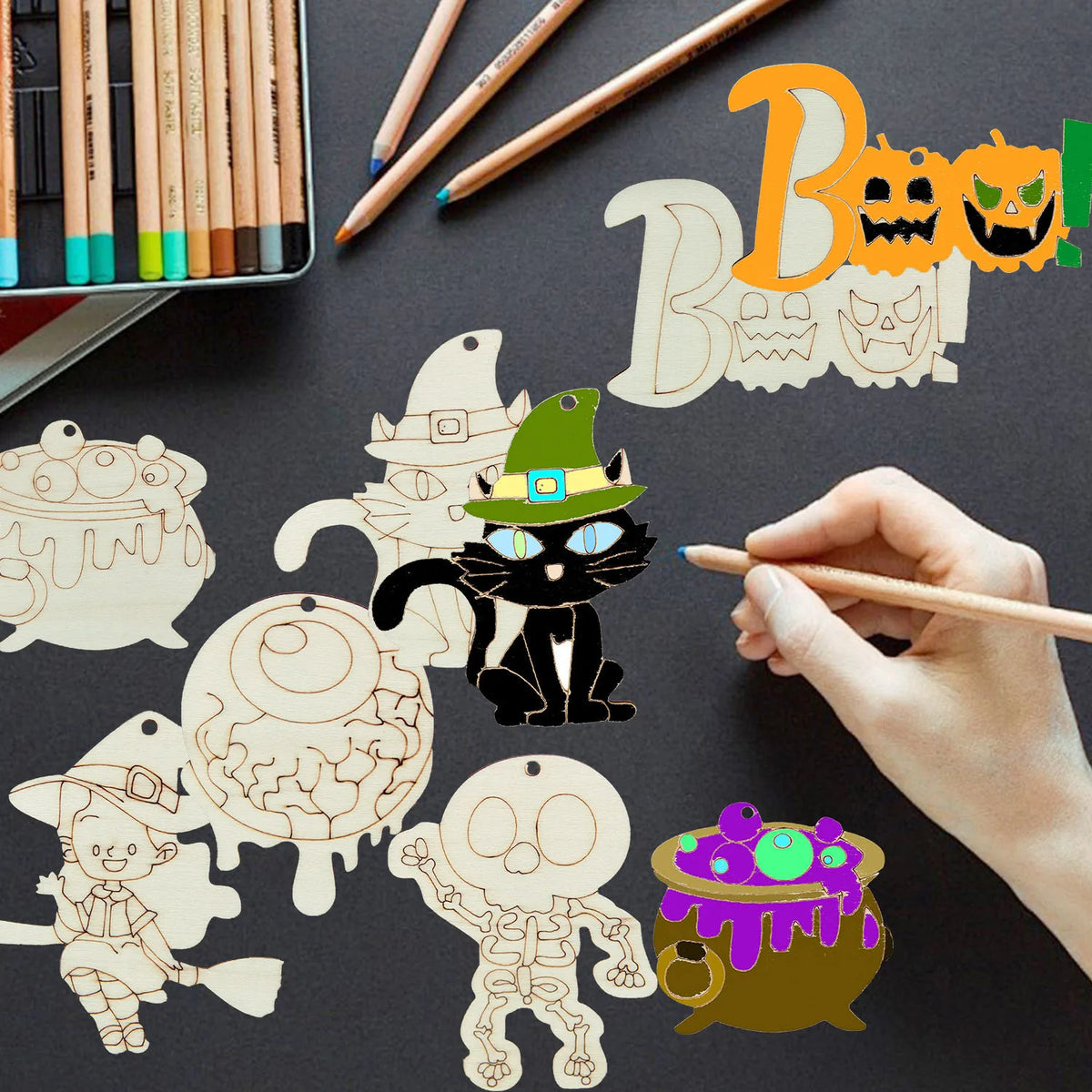 Hand painting wooden Halloween hanging ornaments on a dark surface.