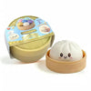 A light green and beige soft squeeze stress ball shaped like a dumpling toy with a decorative lid.
