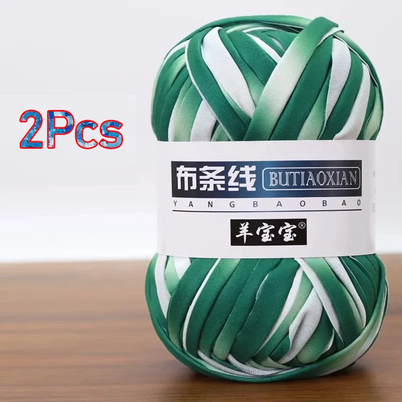 A ball of green and white soft chunky t-shirt yarn for crochet and knitting, packaged as a 2-pack.