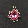 Gold plated water droplet charm featuring a pink crystal rhinestone flower.