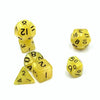A set of seven small yellow polyhedral dice including a d10, d6, and d20.
