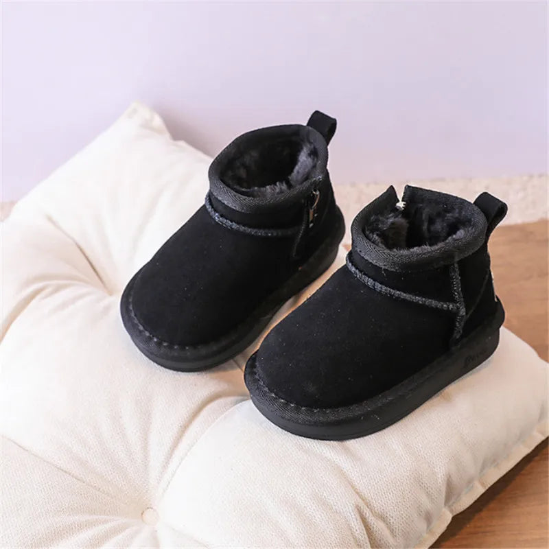 A pair of black faux fur winter snow boots for toddlers resting on a white fabric surface.