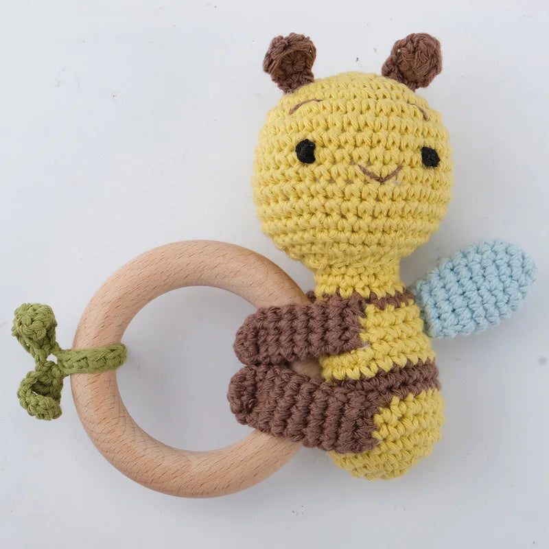 A handcrafted wooden baby rattle and teether ring shaped like an otter, featuring yellow and brown textures.