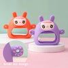 Jouet anti-dents en silicone violet en forme de lapin avec de petits points, présenté sur un socle blanc.