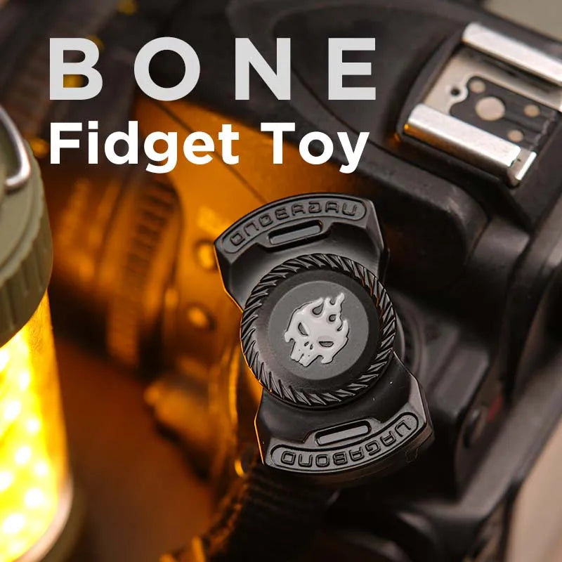 A close-up of a black fidget toy with a skull design mounted on a device.
