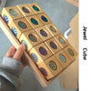 A hand holds a wooden cube puzzle featuring rainbow acrylic building blocks with iridescent colors.