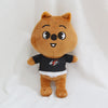 A brown cartoon animal plush toy with large eyes and a black shirt.