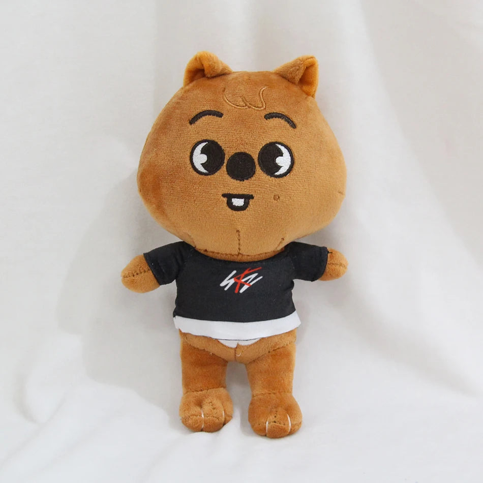 A brown cartoon animal plush toy with large eyes and a black shirt.