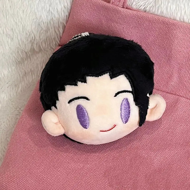 A black and white Jujutsu Kaisen anime plush keychain pendant with purple eyes resting on a pink fabric background.